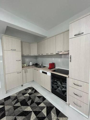 GjakoveCozy Corner Apartment的厨房配有白色橱柜,铺有黑白地板。