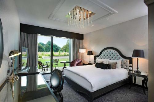 布伦特福德伦敦塞恩公园希尔顿酒店的一间卧室配有一张大床和一个吊灯。