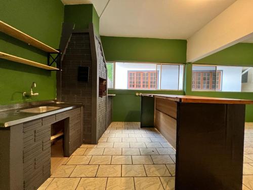 南圣弗朗西斯科Pousada VSC的一间设有绿色墙壁和瓷砖地板的大厨房