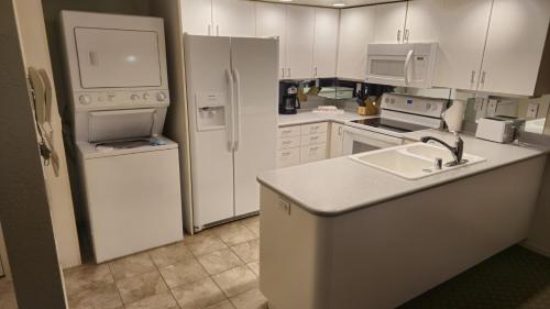 里诺Club Lakeridge的厨房配有白色家电和白色橱柜