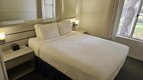 里诺Club Lakeridge的酒店客房配有带白色床单和枕头的床。