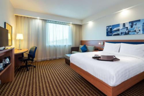 卢顿汉普顿伦敦卢顿机场希尔顿酒店的酒店客房设有一张大床和一张书桌。
