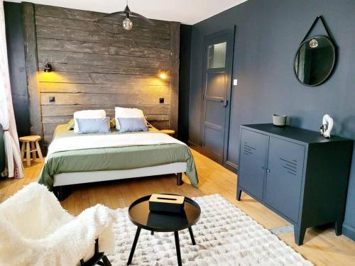 热拉梅Maison Les Planches的一间卧室配有一张床、一张桌子和一面镜子