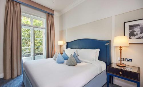 伦敦希尔顿华尔道夫酒店的一间卧室设有一张大床和一个窗户。