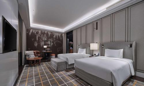 北京北京大兴希尔顿酒店的酒店客房设有两张床和电视。