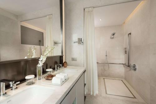 北京北京康莱德酒店 - 希尔顿集团的白色的浴室设有水槽和淋浴。