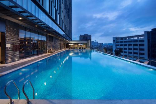 广州广州天河希尔顿酒店 - 免费广交会穿梭巴士 - 采购商办证点的大楼顶部的大型游泳池