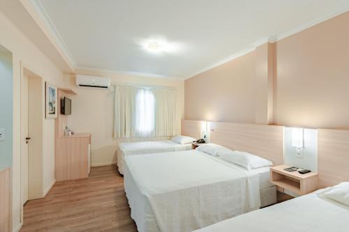 约恩维利Bristol Sabrina Hotel de Charme Joinville的酒店客房设有两张床和窗户。