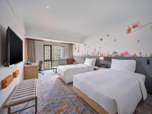 广州Hilton Garden Inn Guangzhou Tianhe- Free Canton Fair Shuttle Bus的酒店客房设有两张床和一台平面电视。