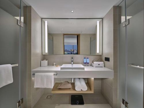 广州Hilton Garden Inn Guangzhou Tianhe的一间带水槽和镜子的浴室