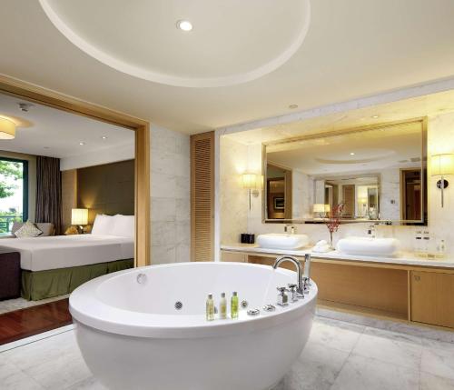 广州广州翡翠希尔顿酒店 - 免费穿梭巴士到广交会的大型浴室设有两个盥洗盆和浴缸。
