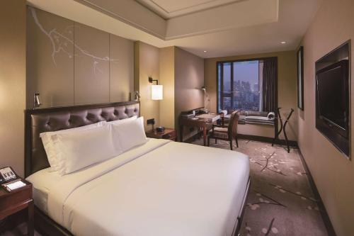 重庆重庆江北希尔顿逸林酒店的酒店客房设有一张大床和一张书桌。