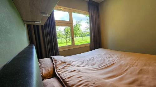 DoornspijkHuisje Weideblik的一间卧室设有一张床和一个窗口