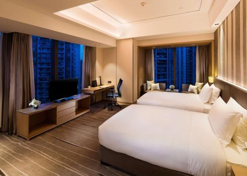 重庆重庆嘉发希尔顿逸林酒店的酒店客房设有两张床和电视。