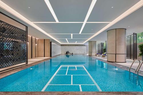 长沙长沙世茂希尔顿酒店的大楼内的一个蓝色海水游泳池
