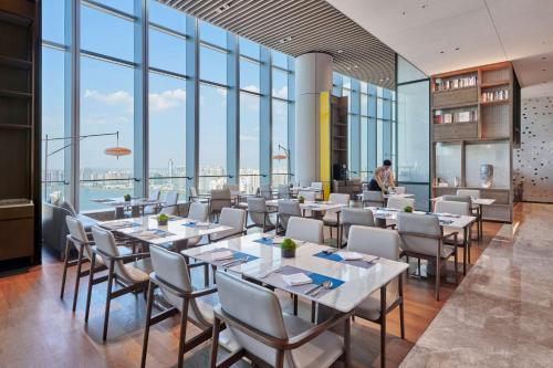 长沙长沙世茂希尔顿酒店的用餐室配有桌椅和大窗户