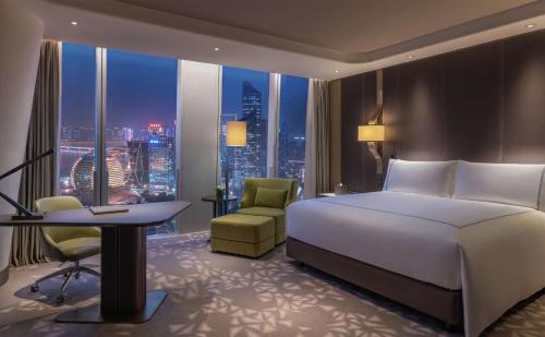 杭州杭州康莱德酒店的配有一张床、一张书桌和一扇窗户的酒店客房