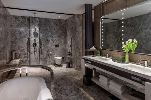 杭州杭州康莱德酒店的带浴缸、水槽和镜子的浴室