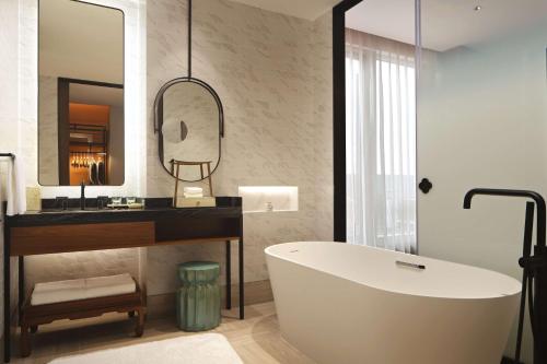 杭州杭州金沙湖和达希尔顿嘉悦里酒店的带浴缸、水槽和镜子的浴室