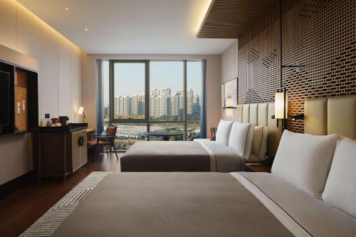杭州杭州金沙湖和达希尔顿嘉悦里酒店的酒店客房设有两张床和大窗户。
