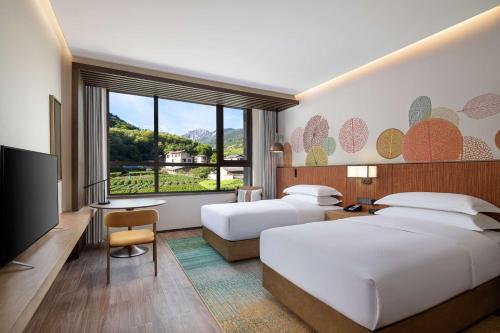 九寨沟九寨鲁能希尔顿花园酒店的酒店客房设有两张床和一台平面电视。