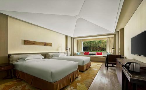九寨沟九寨鲁能希尔顿度假酒店的酒店客房设有两张床和电视。