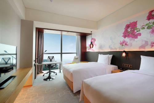 珠海珠海横琴希尔顿花园酒店的酒店客房配有两张床和一张书桌