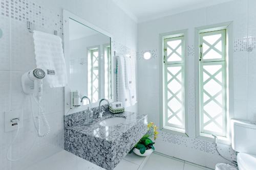 约恩维利Bristol Sabrina Hotel de Charme Joinville的白色的浴室设有水槽和镜子