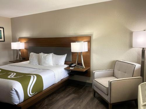 阿拉莫戈多Quality Inn & Suites Near White Sands National Park的配有一张床和一把椅子的酒店客房