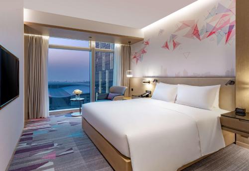 深圳深圳国际会展中心希尔顿花园酒店的酒店客房设有一张白色大床和一个窗户。