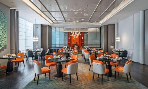 深圳深圳国际会展中心希尔顿酒店的一间在房间内配有桌椅的餐厅
