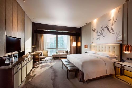 深圳深圳大中华希尔顿酒店（地铁出站即达、近福田会展中心）的一间卧室配有一张大床和电视