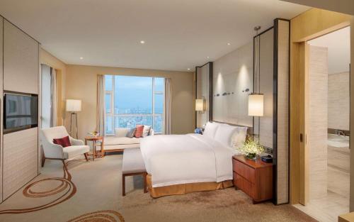 即墨青岛即墨希尔顿逸林酒店（即墨古城）的一间卧室设有一张床和一间客厅。