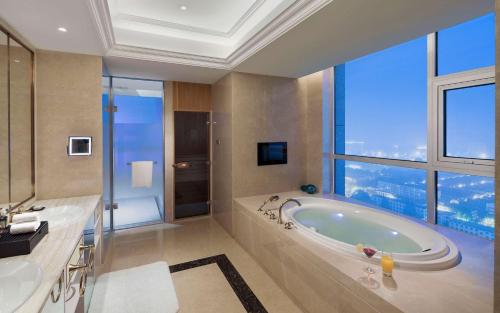 即墨青岛即墨希尔顿逸林酒店（即墨古城）的带浴缸的浴室和大窗户