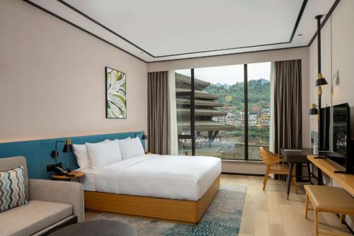 Maotai贵州茅台镇联裕希尔顿花园酒店的配有一张床、一张书桌和一扇窗户的酒店客房