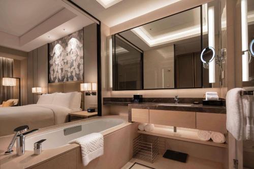 扬州扬州三盛希尔顿逸林酒店的一间带床、浴缸和水槽的浴室