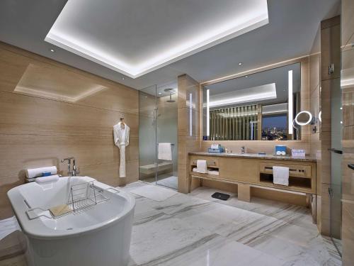 北京北京通州北投希尔顿酒店的带浴缸和镜子的浴室