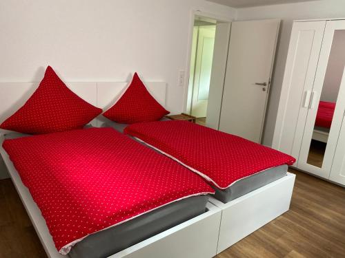 瓦尔茨胡特田根Ferienwohnung am Liederbach的红色的床,上面有红色枕头