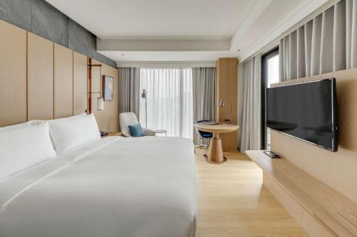 台北台北中山九昱希尔顿逸林酒店的配有一张床和一台平面电视的酒店客房