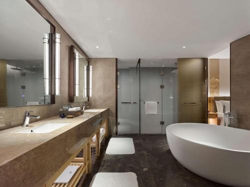 延庆县北京八达岭希尔顿逸林酒店的一间带大浴缸和两个盥洗盆的浴室