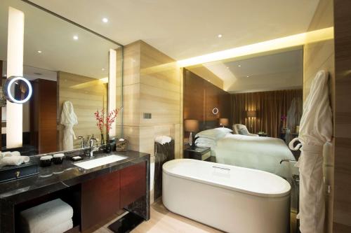 石家庄石家庄希尔顿酒店的带浴缸和床的浴室