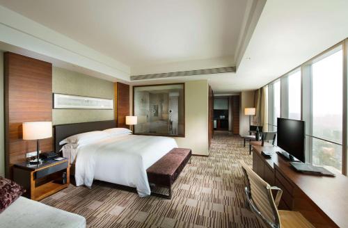 石家庄石家庄希尔顿酒店的配有一张床和一台平面电视的酒店客房