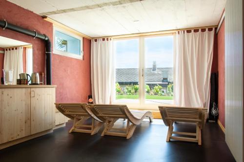 Günsberg  Retreat Lodge Schürmatt -Leben wie SchweizerInnen的客厅配有桌椅和大窗户