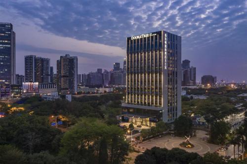 深圳深圳南山希尔顿逸林酒店及公寓的一座高大的建筑,城市里灯火通明