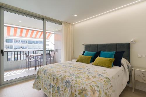 圣阿古斯丁RENOVADO APARTAMENTO 1º LINEA DE MAR的一间卧室配有一张床,阳台配有桌子