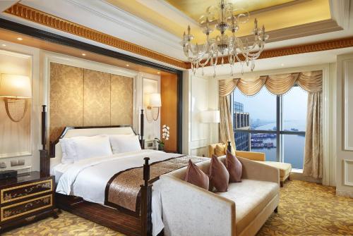 芜湖芜湖世茂希尔顿逸林酒店的一间卧室配有一张大床和一个吊灯。