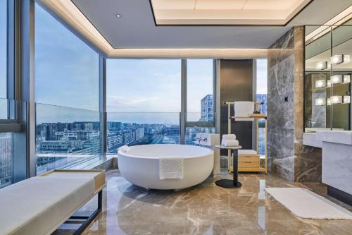 宝安深圳机场希尔顿逸林酒店的带浴缸的浴室,享有美景。