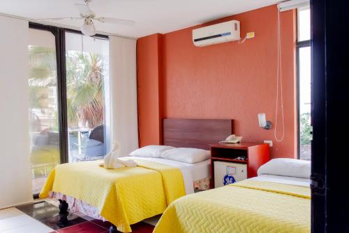曼塔安塔尔酒店的橙色墙壁客房的两张床