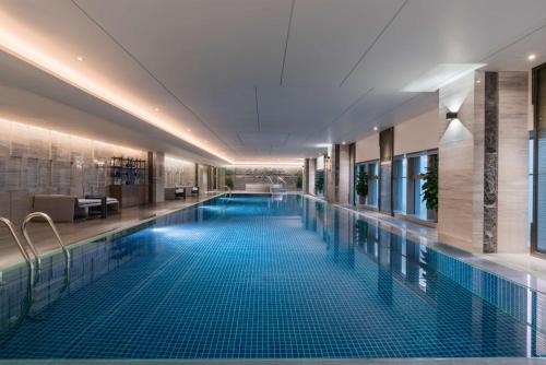 十堰十堰希尔顿逸林酒店的酒店大堂的大型游泳池,设有大型游泳池