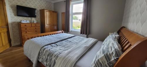 FisherrowMusselburgh / Edinburgh near QM Uni (30)的一间卧室配有一张床、一个梳妆台和一扇窗户。